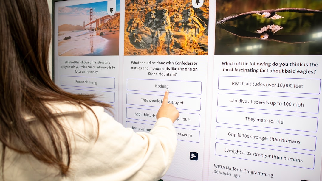 Person checking a social wall with live polls on a TV display in a working space